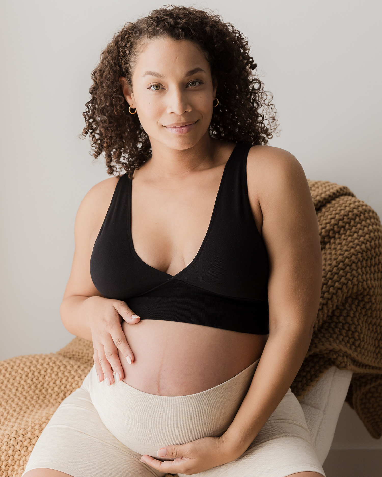 Pregnant model wearing the Sublime Bamboo Maternity & Nursing Plunge Bra in black paired with the Sublime Bamboo Bike Shorts in Oatmeal Heather.@model_info:Alysha is wearing a Large.